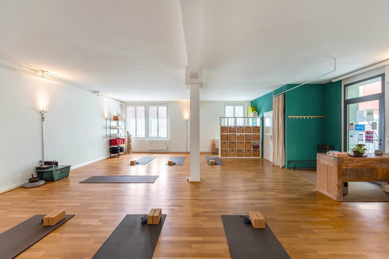 Heller Yoga-Raum mit Matten und Holzblöcken.